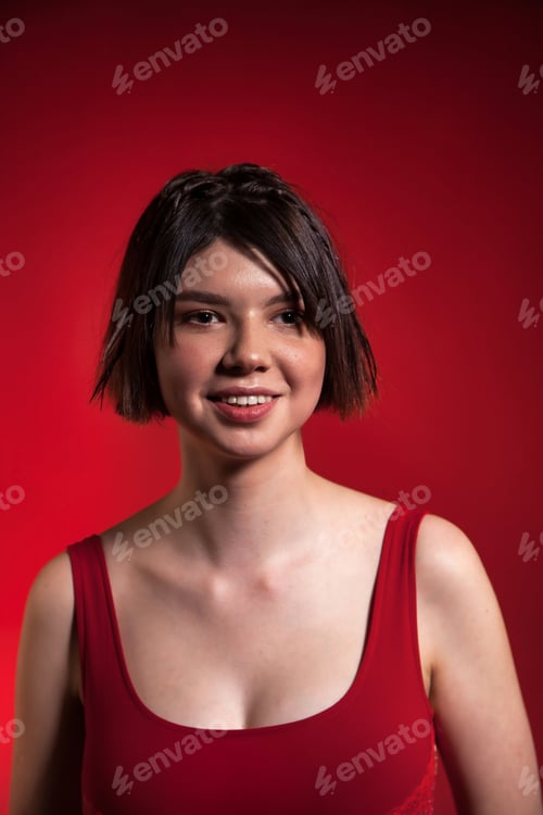 Preview: Portrait teenage girl wear red trendy dress with stylish hairstyle at red background