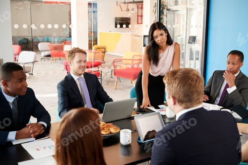 Preview: Female boss stands listening to colleagues at team meeting