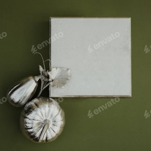 Preview: Autumn flat lay with silver decorated pumpkins and frame for text, green background