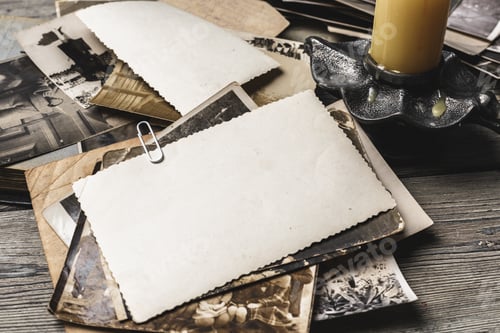 Preview: Old photographs and empty space for memories on wooden table with candle