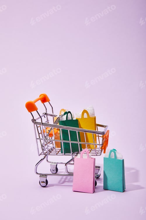 Preview: toy cart with colorful paper shopping bags on violet background