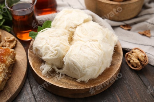 Preview: Eastern sweets. Tasty Iranian pashmak and tea on wooden table, closeup