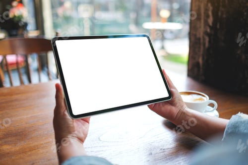 Preview: Mockup image of a woman holding digital tablet with blank white desktop screen in cafe