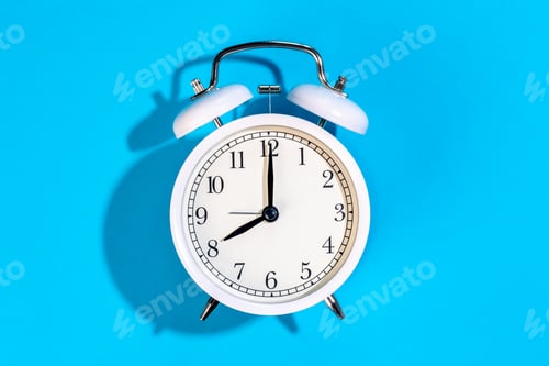 Preview: White alarm clock on a blue background isolated, top view.