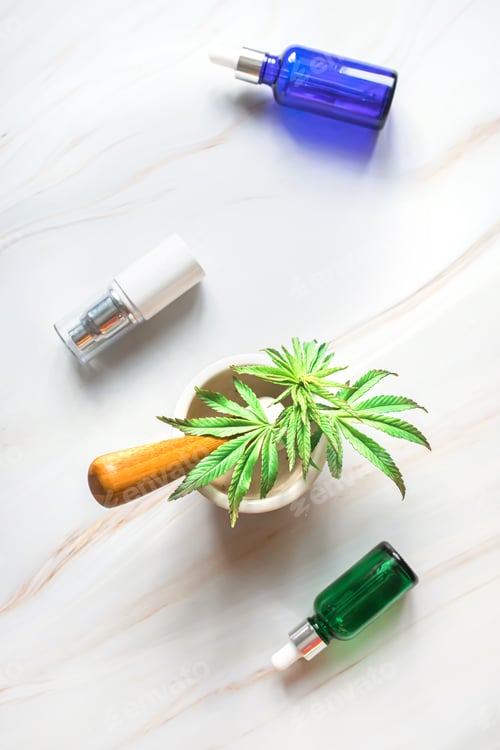 Preview: Cosmetic products on a marble table with a young sprout of hemp. Hemp products for body and face