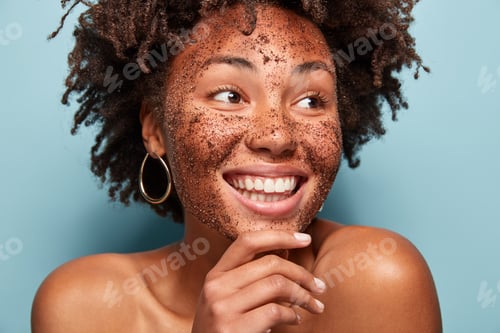 Preview: Natural beauty, spa and healthy skin concept. Glad African American woman peels skin with coffee scr