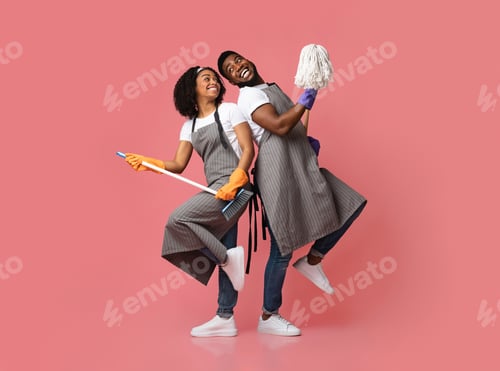 Preview: Joyful Black Couple Having Fun During Spring-Cleaning, Dancing With Mop And Broom