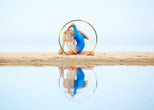 Preview: Outdoor Portrait Of Young Beautiful Blonde Woman Gymnast Working Out With Hula Hoop On The Beach