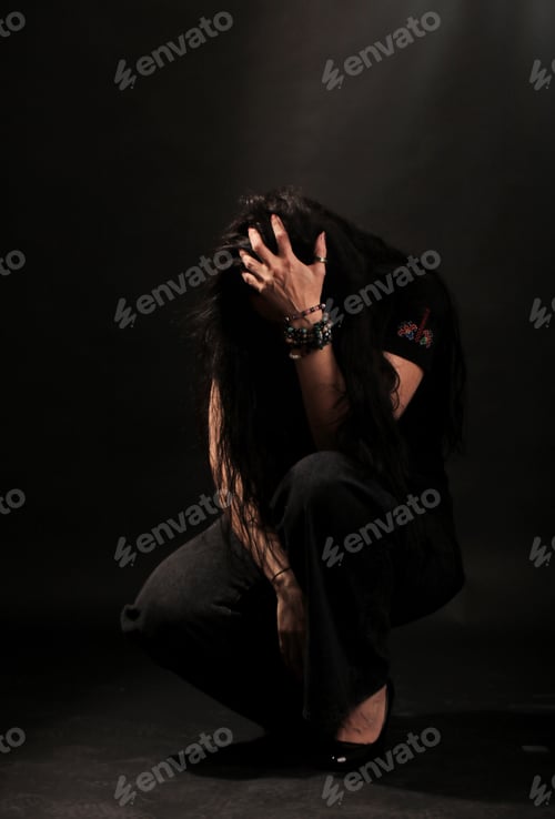 Preview: Beautiful dramatic light and woman holding her head with her hand