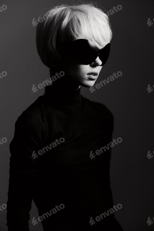 Preview: Stylish woman with short hair wearing oversized sunglasses, dressed in a black turtleneck top