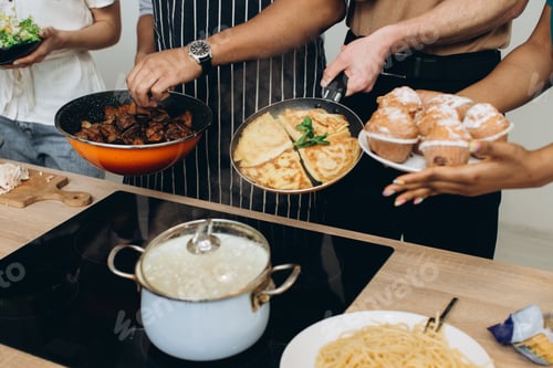 Preview: Friends preparing various dishes for dinner meal
