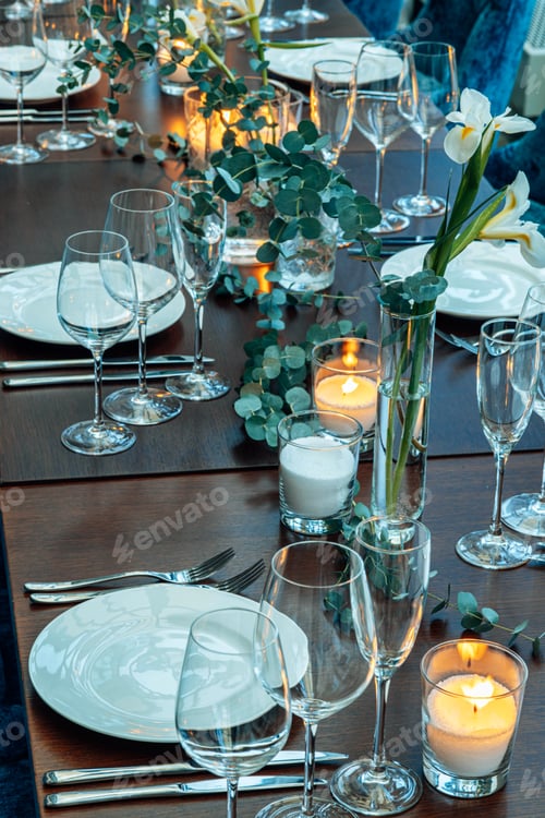 Preview: Table setting. On the banquet table there are plates with napkins and name cards, glasses and cutler
