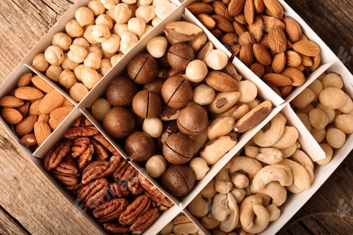 Preview: Different grade of nuts in a box on a wooden background top view