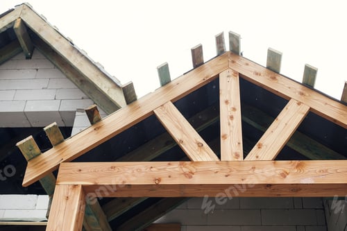 Preview: Unfinished house. Wooden roof framing with vapor barrier and dormer on block walls with windows