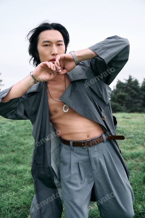 Preview: Stylish young man showcases fashion in a serene park setting