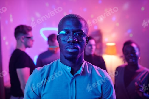 Preview: Serious guy of African ethnicity in casualwear and eyeglasses looking at you
