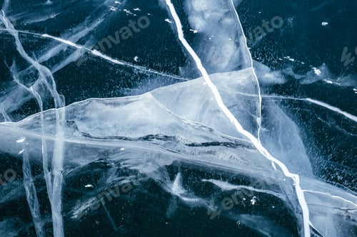 Preview: Amazing patterns of cracks on the frozen ice of Lake Baikal in winter. Abstract background.