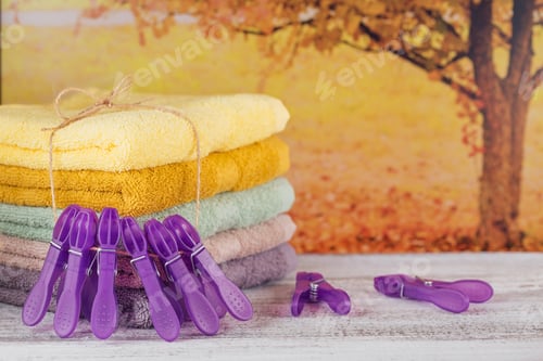 Preview: Stack of colorful bath towels on light wooden board.