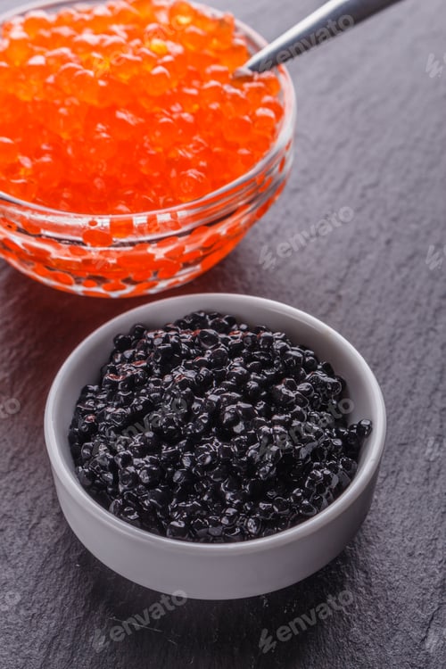 Preview: red and black caviar in a bowl on a dark stone background