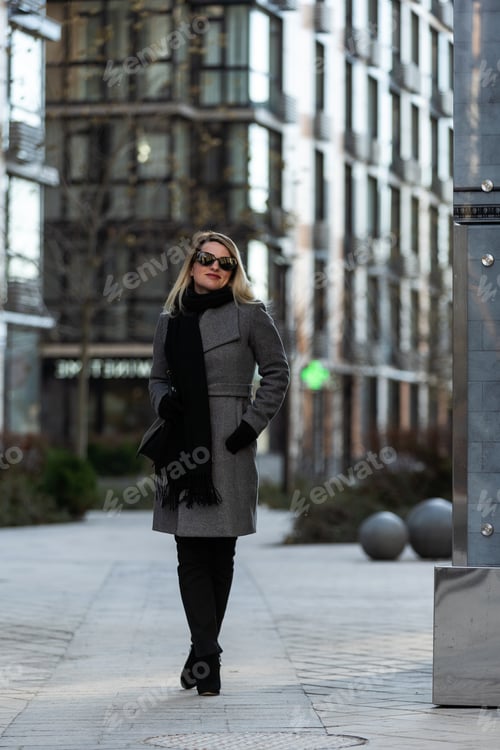 Preview: Beautiful girl in a ccoat and scarf and black glasses
