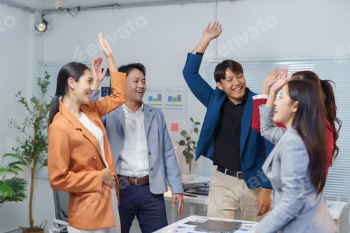 Preview: Happy business team celebrating success raising hands in office