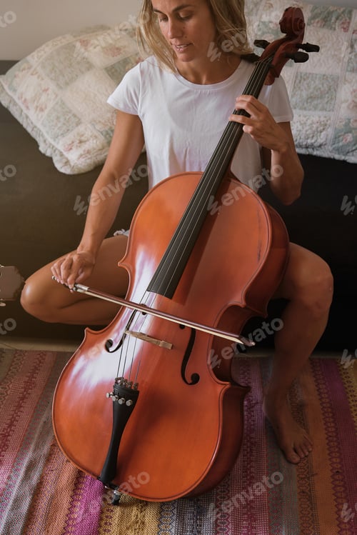 Preview: Crop woman playing cello at home