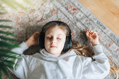 Preview: Cute little girl listening to music in headphones