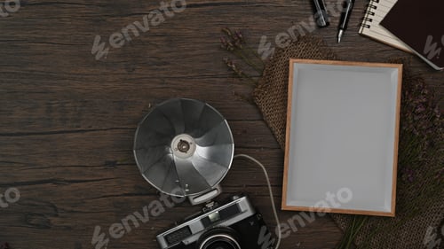 Preview: Above view retro camera, empty picture frame and notebook on wooden background.