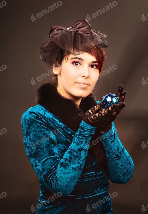 Preview: Portrait of happy young woman holding christmas ball