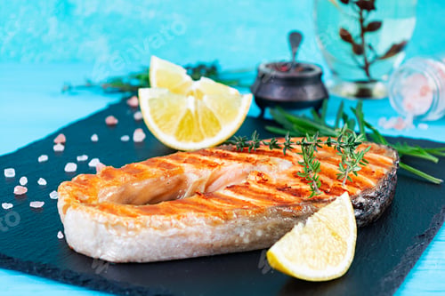 Preview: Grilled salmon fish on stone board. Salt atlantic salmon fried on grill with lemon