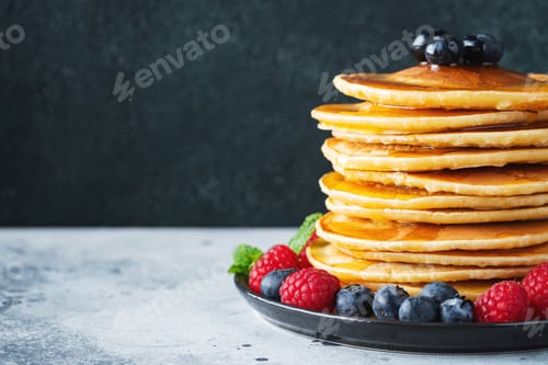 Preview: Delicious pancakes, with fresh blueberries, raspberry and maple syrup or honey on a dark background