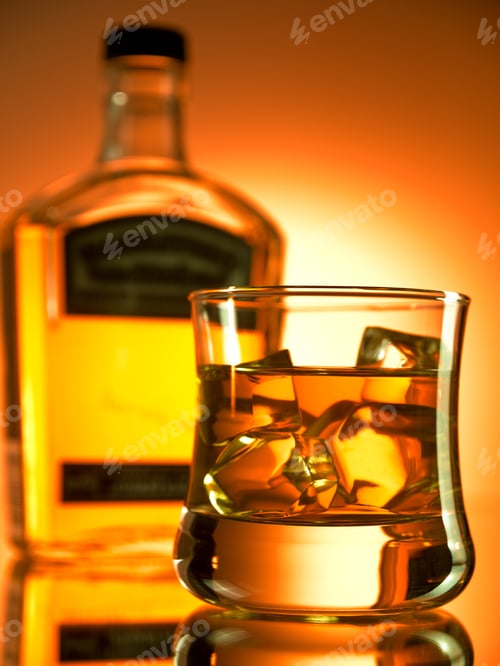 Whiskey and Ice in Clear Glass with Bottle