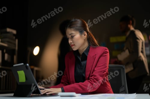 Preview: Professional Businesswoman Working Late in Modern Office with Tablet and Documents