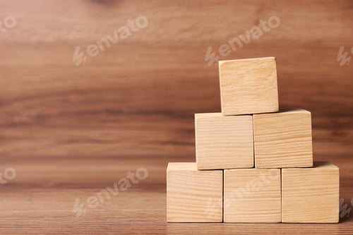 Preview: Pyramid of cubes on wooden background, space for text. Idea concept