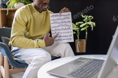 Preview: Young confident teacher pointing at music sheet