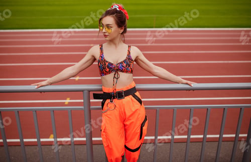 Preview: Relaxed sportswoman near race track
