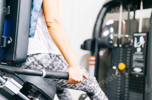 Preview: Woman strengthening her legs in the gym machine