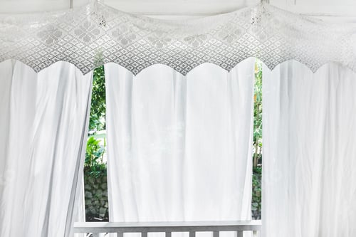 Preview: White curtains with patterns on veranda of residential wooden house. Balcony in rustic