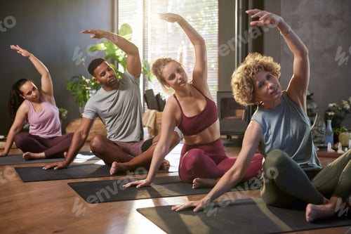 Preview: Diverse people practicing yoga in fitness outfit while stretching arm