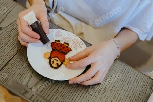 Preview: One girl is coloring cookies while sitting at the table.