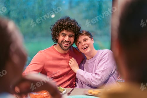 Preview: Happy couple enjoying dinner party with friends