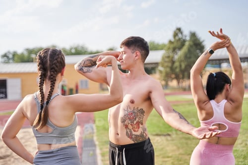 Preview: three young sportsmen posing. portrait of friends stretching after training.