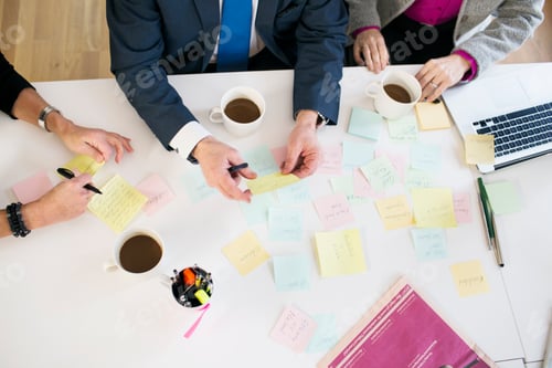 Preview: High angle view of business people with reminders at office desk