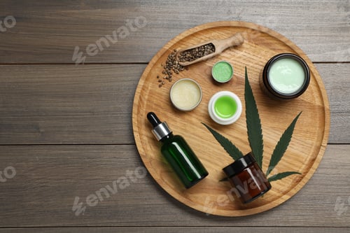 Preview: Different hemp cosmetics, green leaf and seeds on wooden table, top view. Space for text