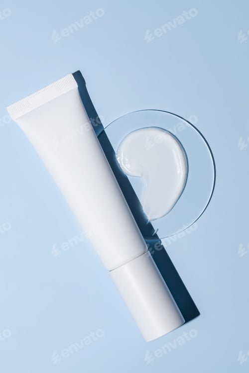 Preview: White pomp tube of face or hand cream and sample texture in petri dish on blue background. Cosmetic