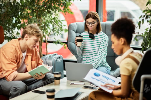 Preview: Colleagues collaborate at a hotel during a productive business trip in a cozy lounge area