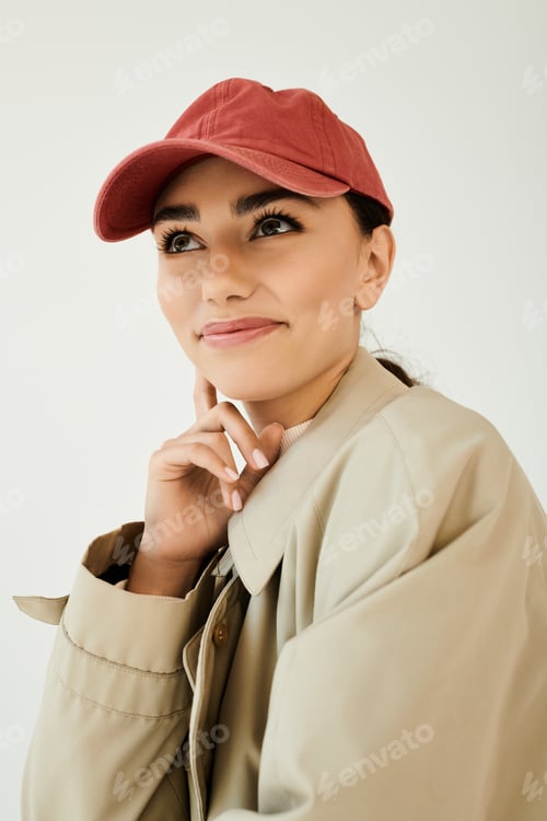 Preview: Stylish young woman showcases autumn fashion in cozy studio setting with playful charm