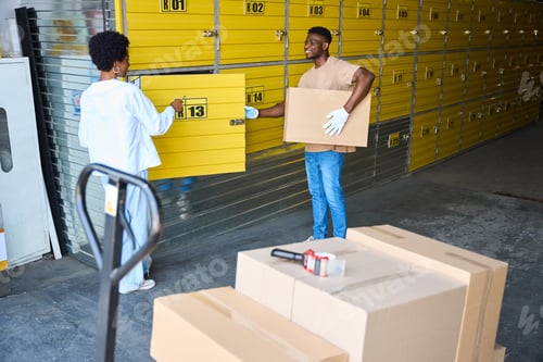 Preview: African American man loading a cardboard box into storage unit