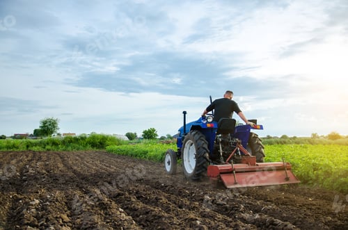 Preview: A farmer on a tractor grinds the soil before planting a new crop.