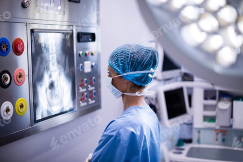 Preview: Medical Professional Examining X-ray Image in Hospital Room